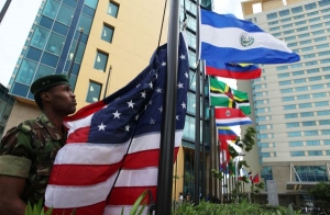 Trinidadský voják vytahuje vlajku USA před hotel summitu OAS.
